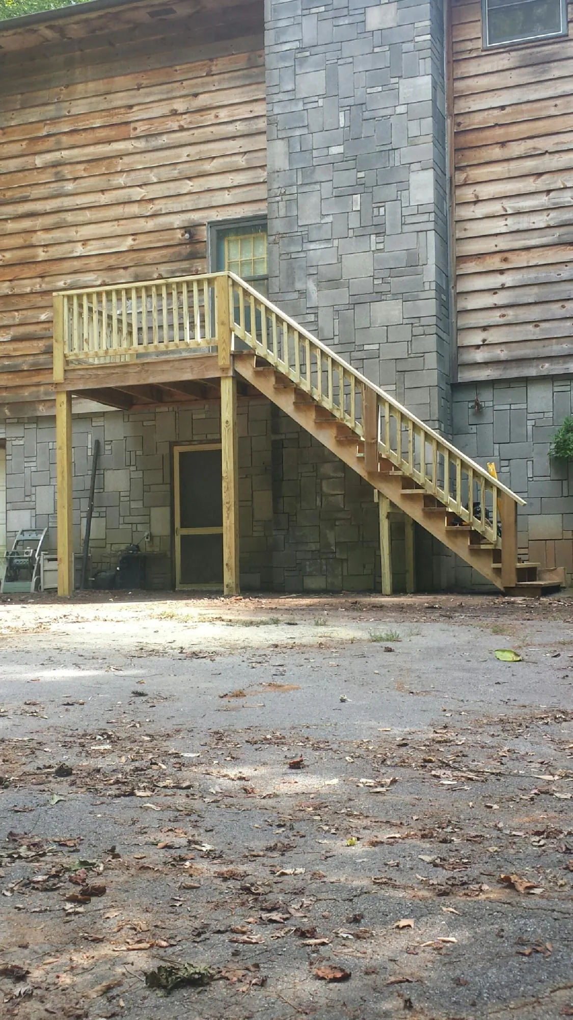 New pressure treated deck and stair landing on a log home in Marsing
